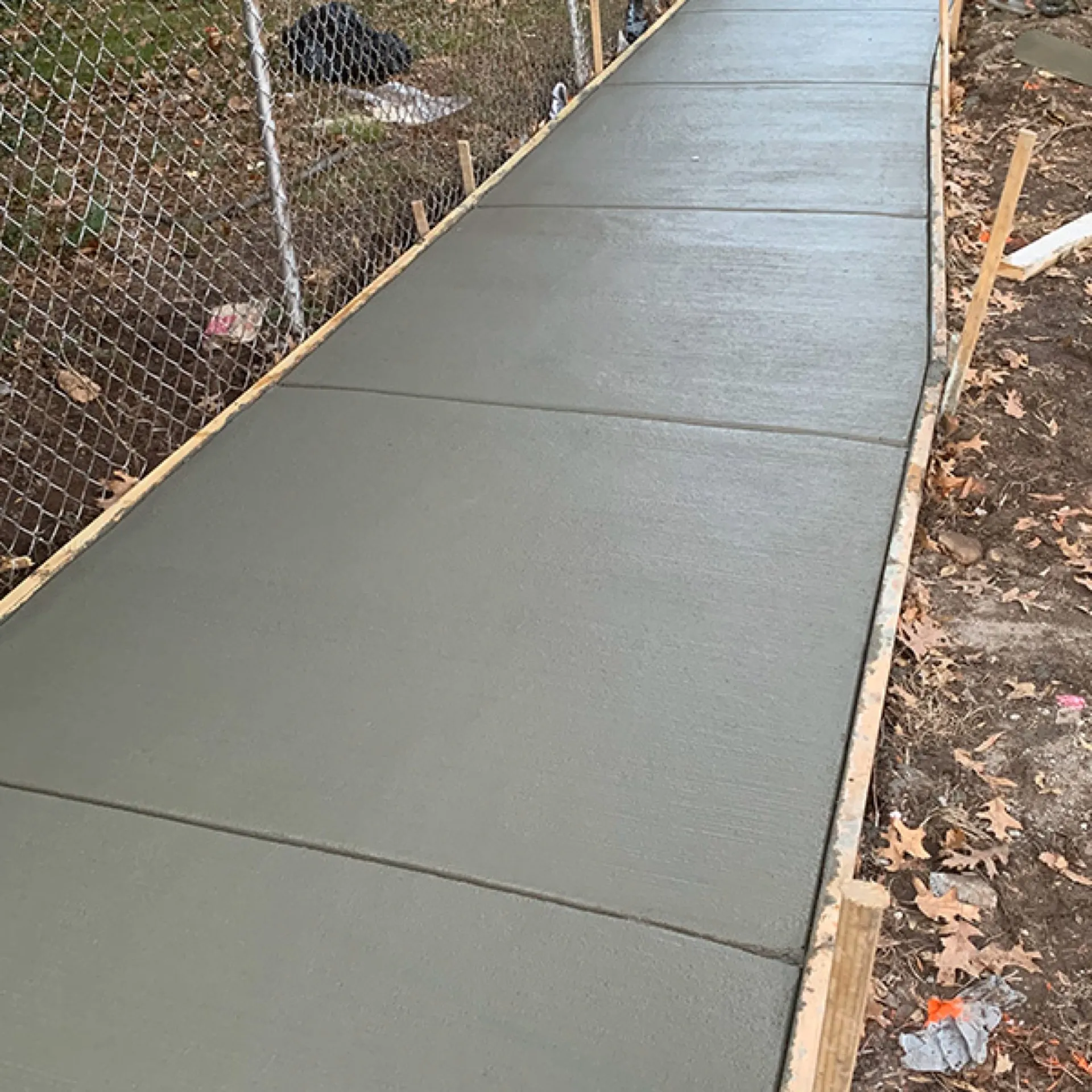 Narrow concrete walkway fresh pour still in wooden forms Cherry Hill NJ